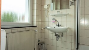 A bathroom with a toilet, sink, and shower. - Hotel Stockumer Hof (Werne)