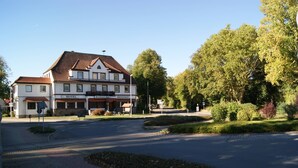 A hotel with a traditional European architectural style, featuring a tiled roof and a signboard indicating it offers a restaurant. - Hotel Stockumer Hof (Werne)