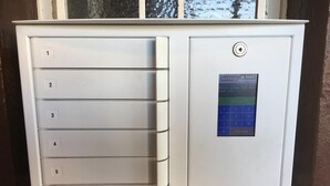 A white, metallic, numbered storage unit with a keypad on the right side. - Hotel Stockumer Hof (Werne)