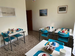 A dining area with tables and chairs, some with food and drinks. There are framed pictures on the walls. - Bed and Breakfast Elisa (Sonnino)