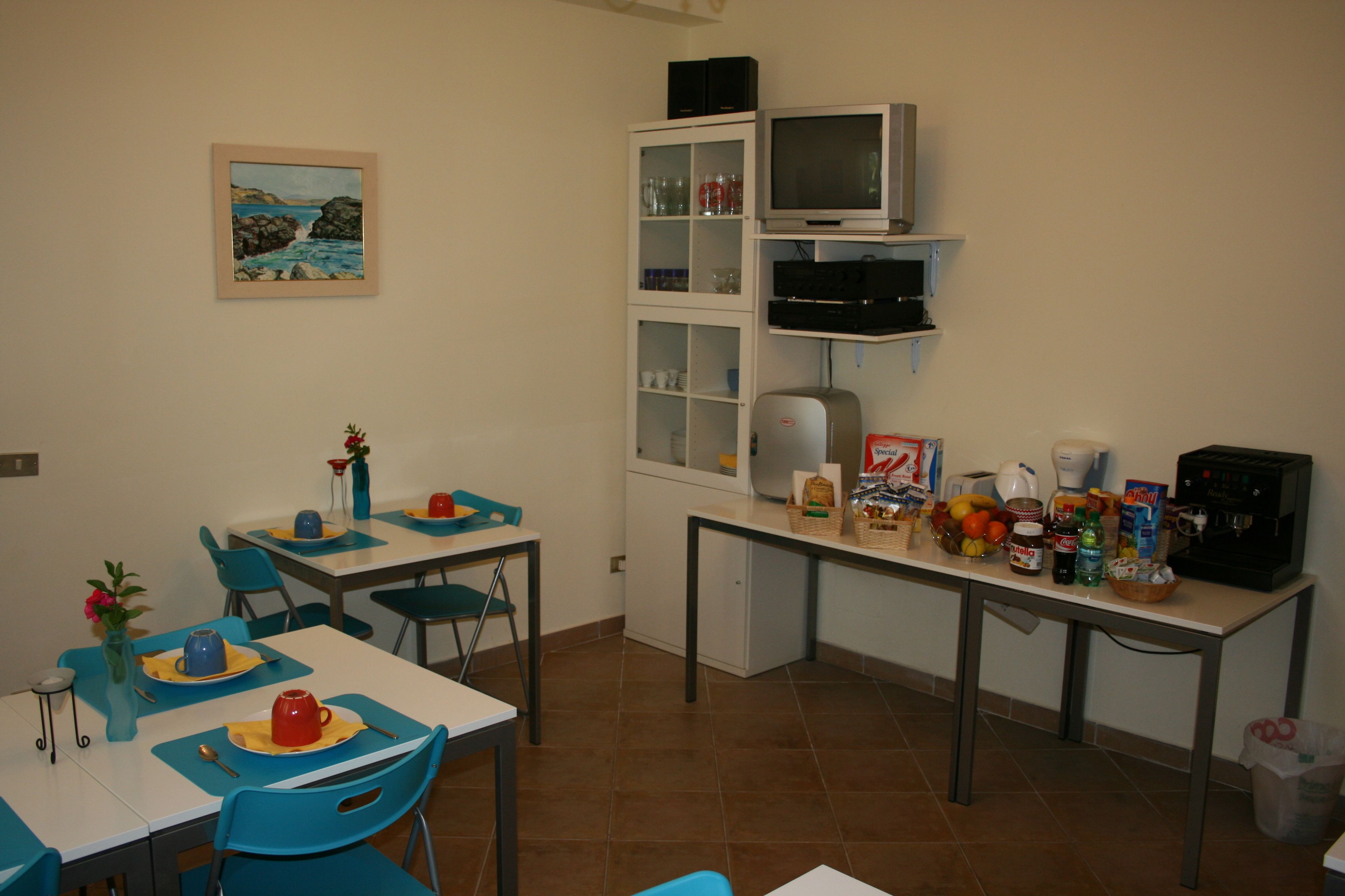 Un comedor con sillas azules, una mesa blanca y un cuadro en la pared.