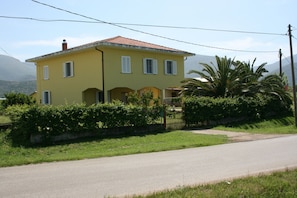 A two-story yellow house with a red-tiled roof, a small front porch, and a gate. - Bed and Breakfast Elisa (Sonnino)