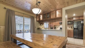 A spacious kitchen with wooden cabinets, a large wooden table, and a built-in refrigerator. - Clean and fresh remodeled Lake Forest Glen End Unit (Tahoe City)