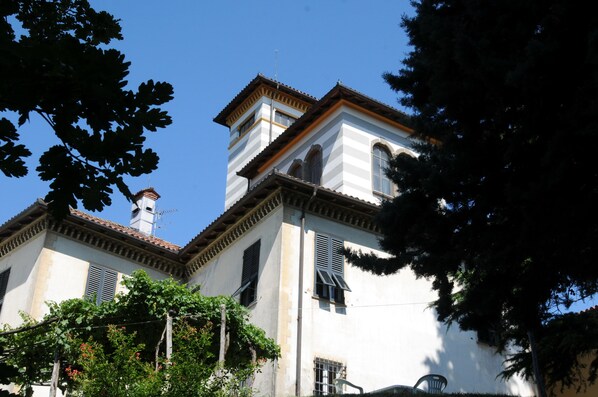 Un edificio con fachada blanca, una torre de campanas y techo de tejas.