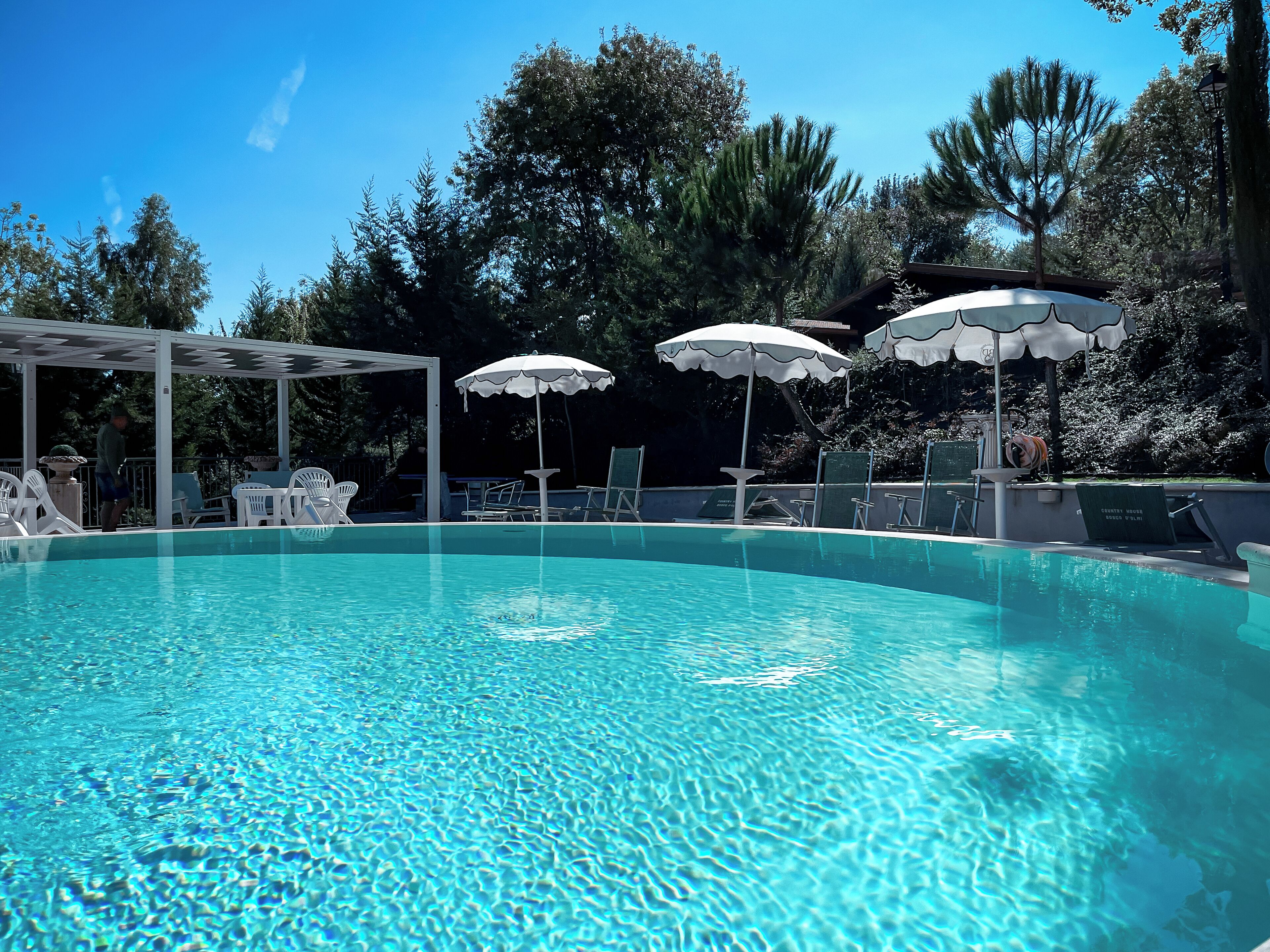 Ein klarer Swimmingpool mit Liegestühlen und Sonnenschirmen.