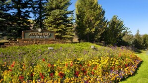 A sign for Arrowhead Country Club of the Rockies surrounded by a vibrant flower garden. - Exclusive Arrowhead Village Condo, Steps from the Lift, garage, ski locker!! (Edwards)