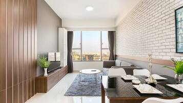 Una sala moderna con comedor, ventanas amplias y vista a la ciudad.