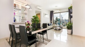 A modern living room with a dining area, a sofa, and a balcony with a city view. - Trip Apartment Saigon (Ho Chi Minh City)