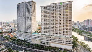 Two high-rise buildings with a river in the background. - Trip Apartment Saigon (Ho Chi Minh City)