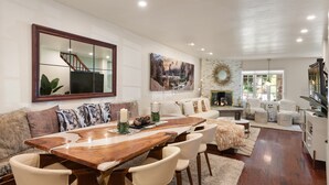 A spacious living area with a wooden dining table, comfortable seating, a fireplace, and a large mirror. -  Aspen Core Designer 4 Bdrm, Walk to Everything , A/C, Parking (Aspen)