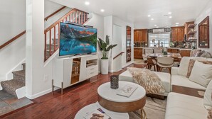 A modern living room with a flat-screen TV, a dining area, and a kitchen. -  Aspen Core Designer 4 Bdrm, Walk to Everything , A/C, Parking (Aspen)