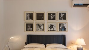 Ein Hotelzimmer mit einem großen Bett, einem Nachttisch mit Lampe und einem Wandbild mit gerahmten Bildern.