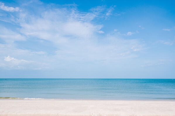 A beach with a clear sky and calm sea.