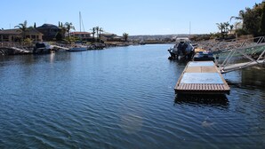 A marina with boats docked, a wooden dock, and houses in the background. - Marina's Holiday Retreat (Port Lincoln)