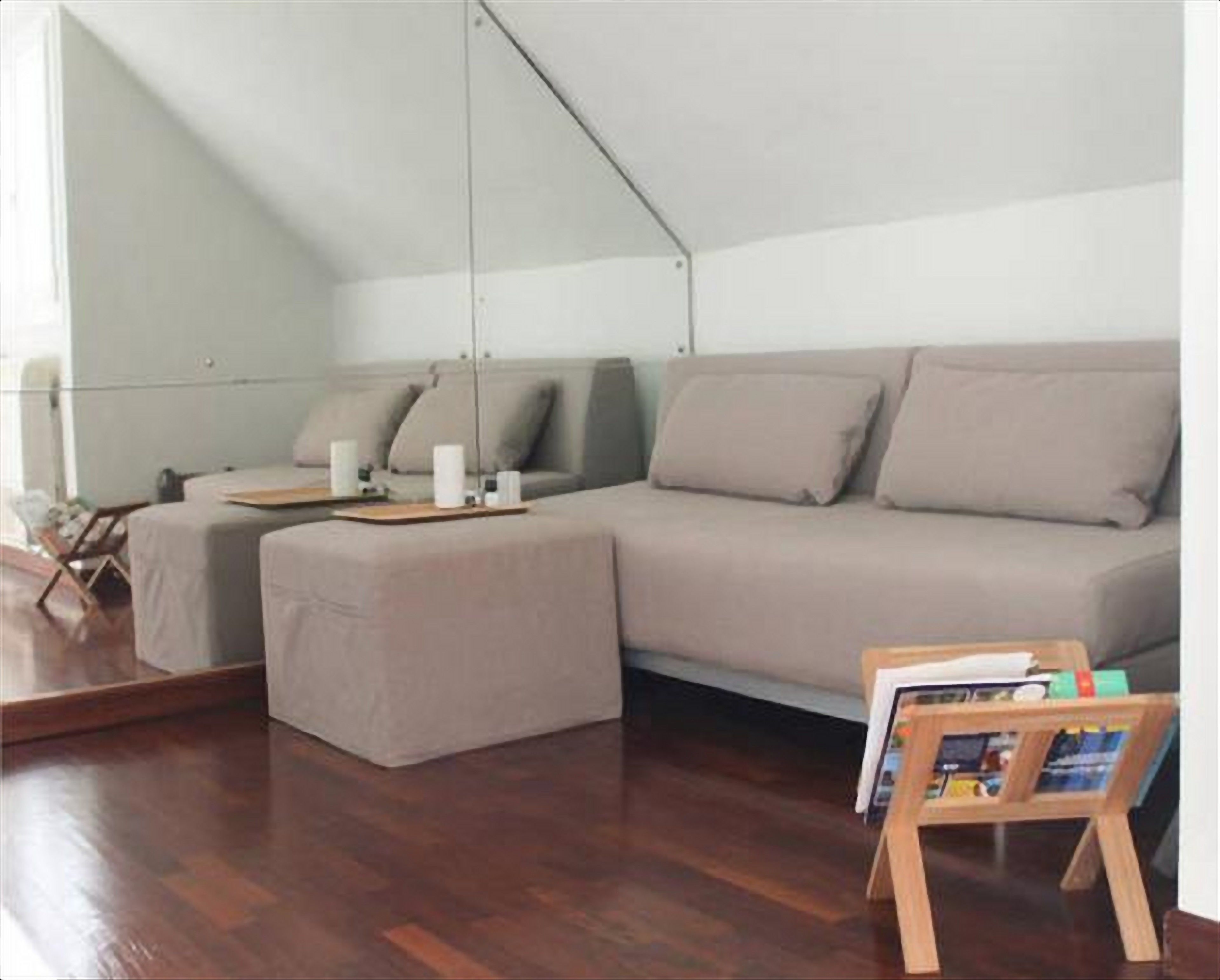 Ein modernes Wohnzimmer mit einer Couch, einem kleinen Tisch und einem Zeitschriftenständer.