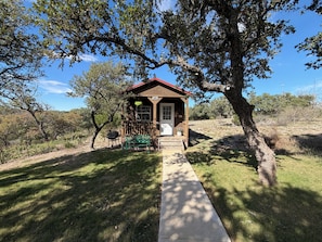 Eine Holzhütte mit rotem Dach, einer Veranda und einem Weg, der dorthin führt.