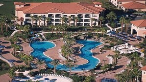 A resort with a large central pool, multiple guest rooms, and palm trees. - Orange Lake Resort: Next to Disneyworld, Near Universal, Sea World & Legoland  (Kissimmee)