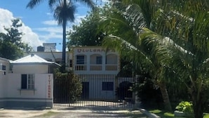 Un edificio con una entrada porticada, un letrero que dice 'VIVIENNES' y una palmera en primer plano.