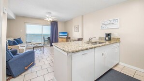 Un espacio habitable compacto con kitchenette, comedor y balcón con vistas.