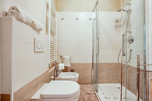 A modern bathroom with a glass-enclosed shower, two sinks, and a toilet. - Vitruvio (Milan)