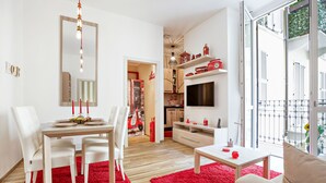 A modern living room with a dining area, a TV, and a balcony with a view. - Vitruvio (Milan)