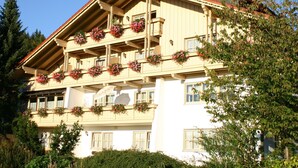 A multi-story building with balconies adorned with flower boxes. - Haus Vierjahreszeiten (Bodenmais)