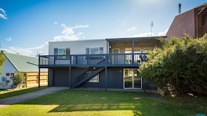 A two-story house with a balcony, a garage, and a well-maintained lawn. - House One @ Potato Point (POTATO POINT)