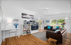 Ein modernes Wohnzimmer mit Kamin, einer Couch, einem Couchtisch und einem Bücherregal.