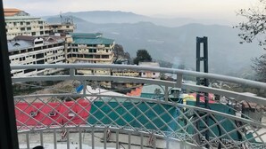A view from a balcony overlooking a mountainous landscape with buildings in the foreground. - Hotel One Mall Road Murree (Murree)