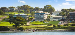 Une zone résidentielle côtière avec des maisons, une vue dégagée sur la mer et un littoral rocheux.