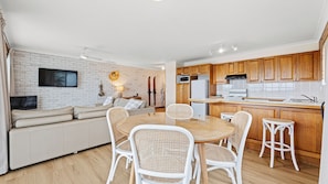 A modern apartment with a living room, dining area, and kitchen. - Grand Pacific 1 Unit 1 - Ground Floor (NAROOMA)