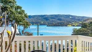Ein Balkon mit Blick auf einen See, Bäume und Hügel.