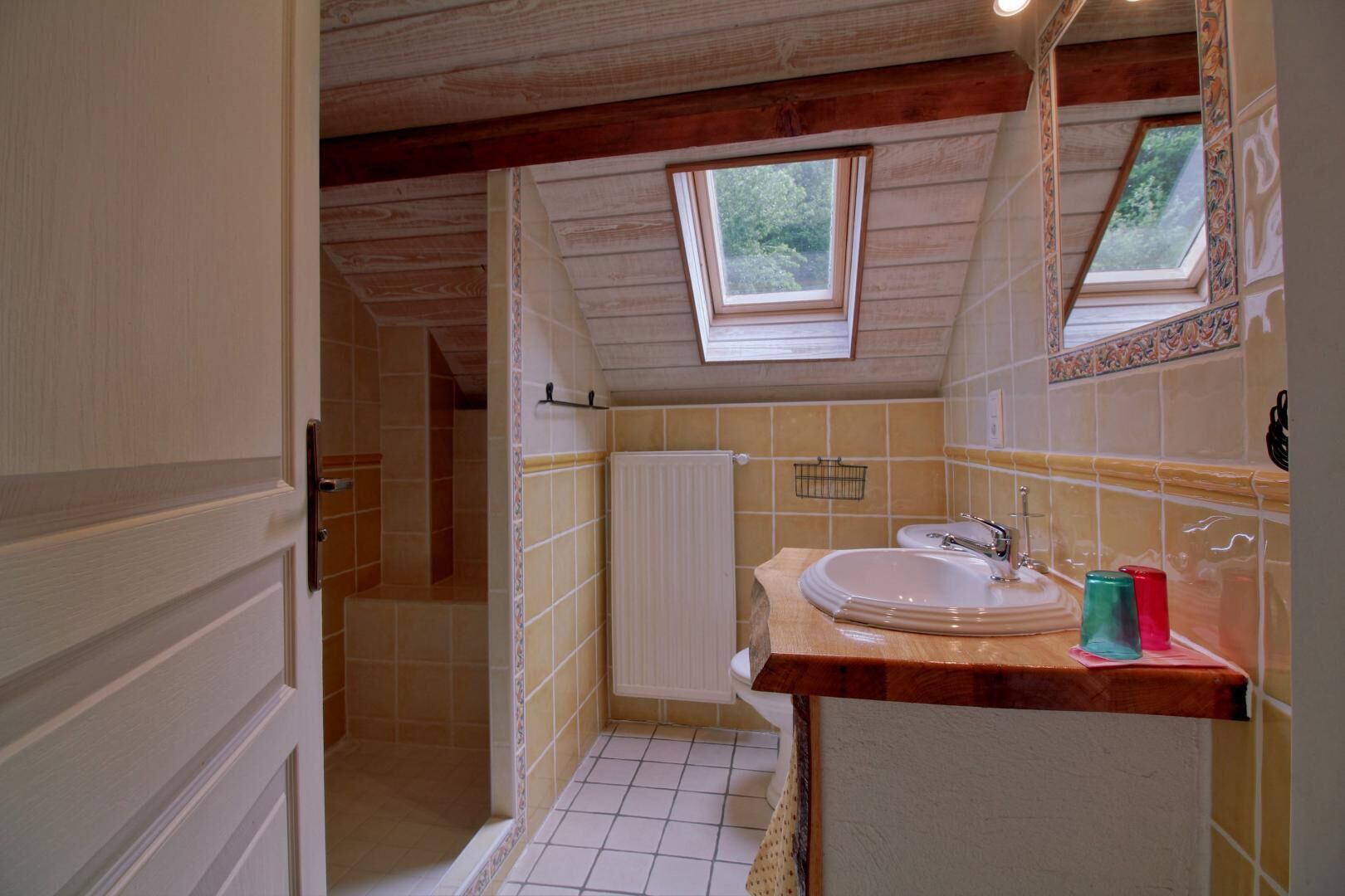 Une salle de bain avec un puits de lumière, un lavabo et des toilettes.