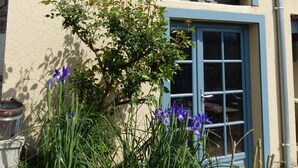 A two-story building with a balcony and a window with a view of the sky. - Chambres d'hôtes Las Vignes (Beaucens)