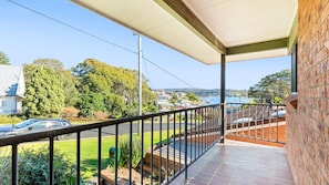 A balcony with a view of a residential area, a road, and a body of water. - Bayview Unit -  Stunning Inlet Views (Narooma)