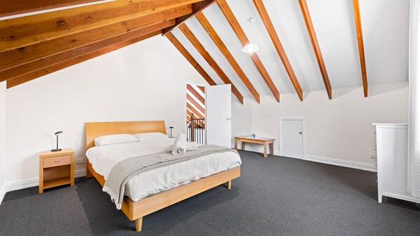 A bedroom with a wooden bed, a nightstand, a desk, and a wardrobe. - Bush Retreat With Private Pool (NAROOMA)
