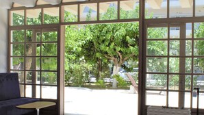 A spacious room with a large window, a sofa, and a radiator. - Apollon Hotel - Adults Only (Agios Nikolaos)