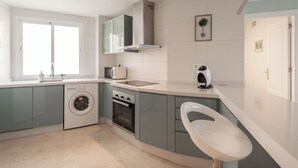 A modern kitchen with a washing machine, oven, microwave, and a sink. - Apartment with sea view, parking, wifi (Marbella)