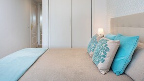 A bedroom with a bed, a nightstand, a lamp, and a patterned wall. - Apartment with sea view, parking, wifi (Marbella)