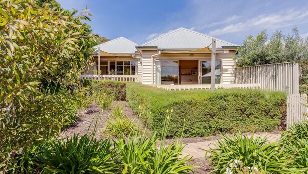 A two-story house with a covered patio and a fenced backyard. - ST PAULS PINK BAYSIDE SELF CONTAINED COTTAGE IN SORRENTO (Sorrento)