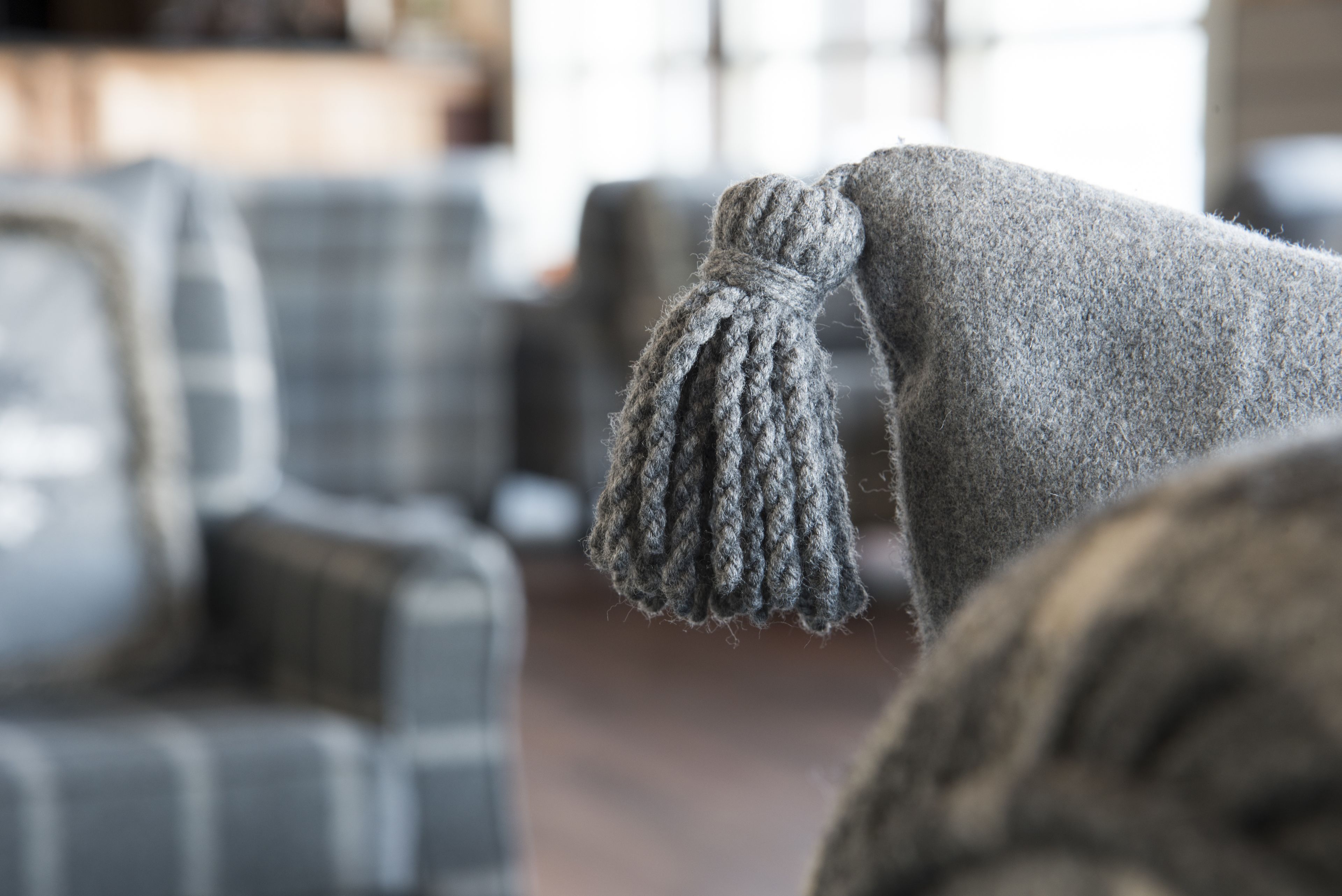 A close-up of a knitted item with a tassel, likely part of a larger piece of clothing or decor.