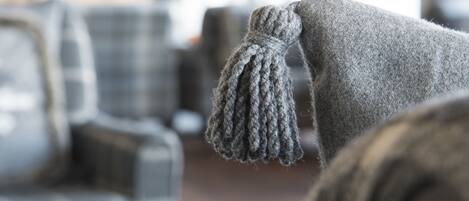 A close-up of a knitted item with a tassel, likely part of a larger piece of clothing or decor.