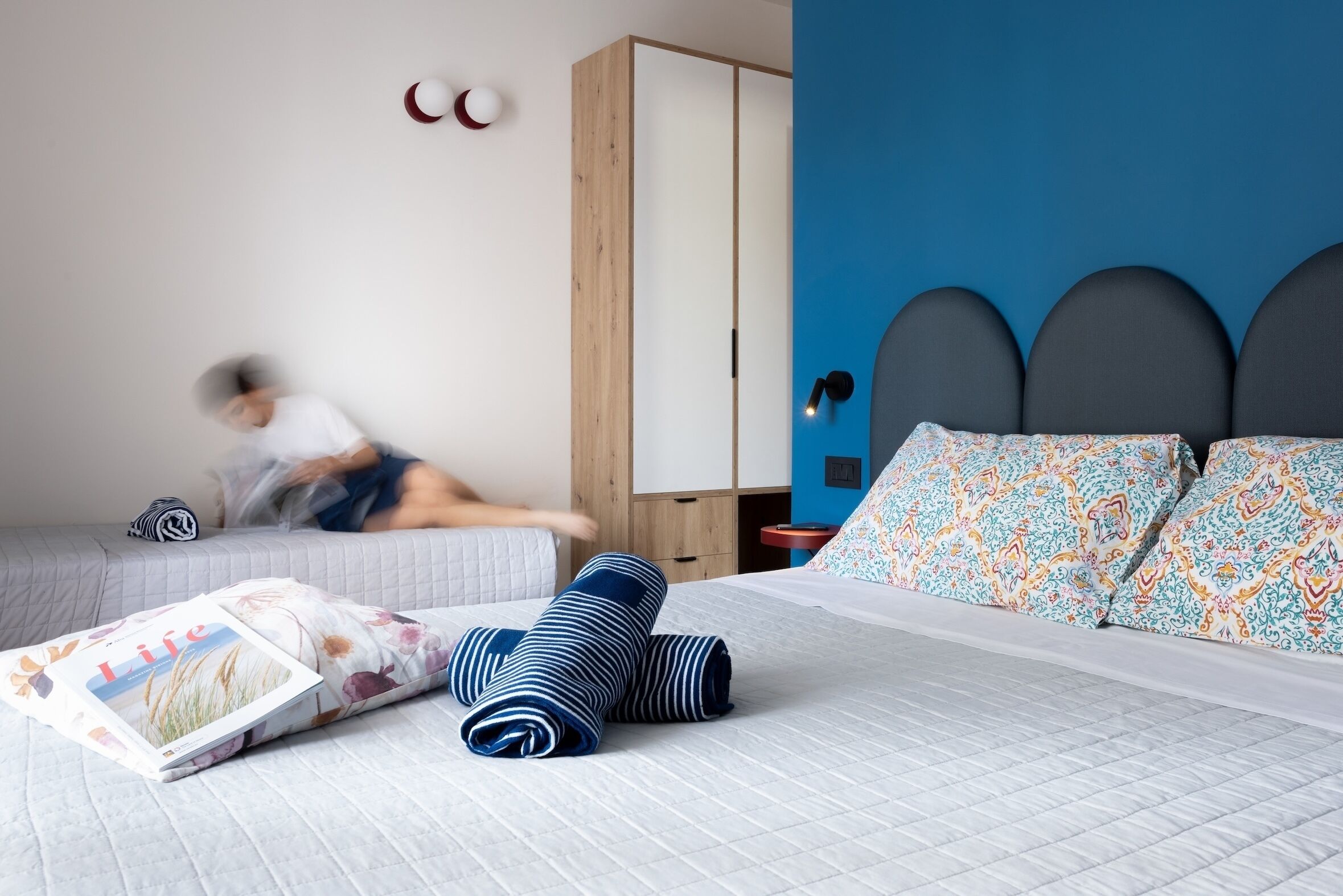 A bedroom with a bed, pillows, a bedside table, and a wardrobe.