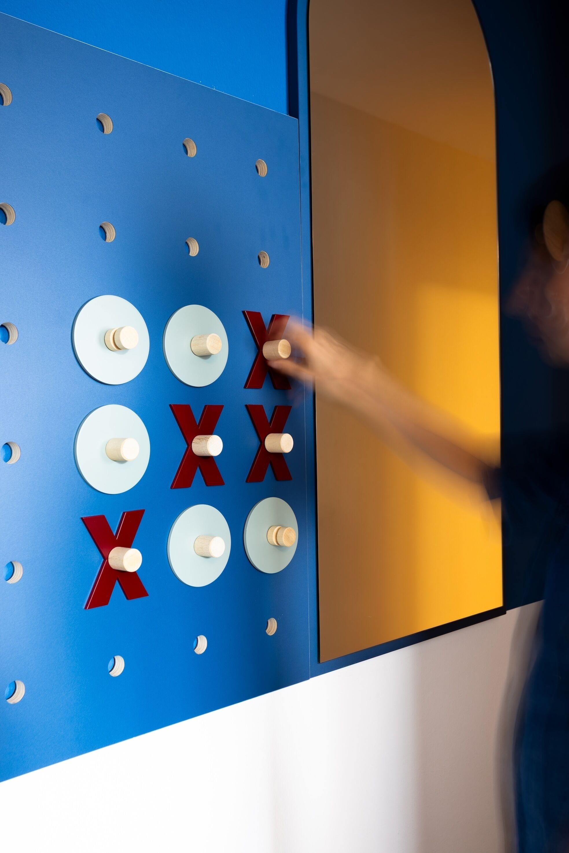 A wall with circular holes and red 'X' symbols.