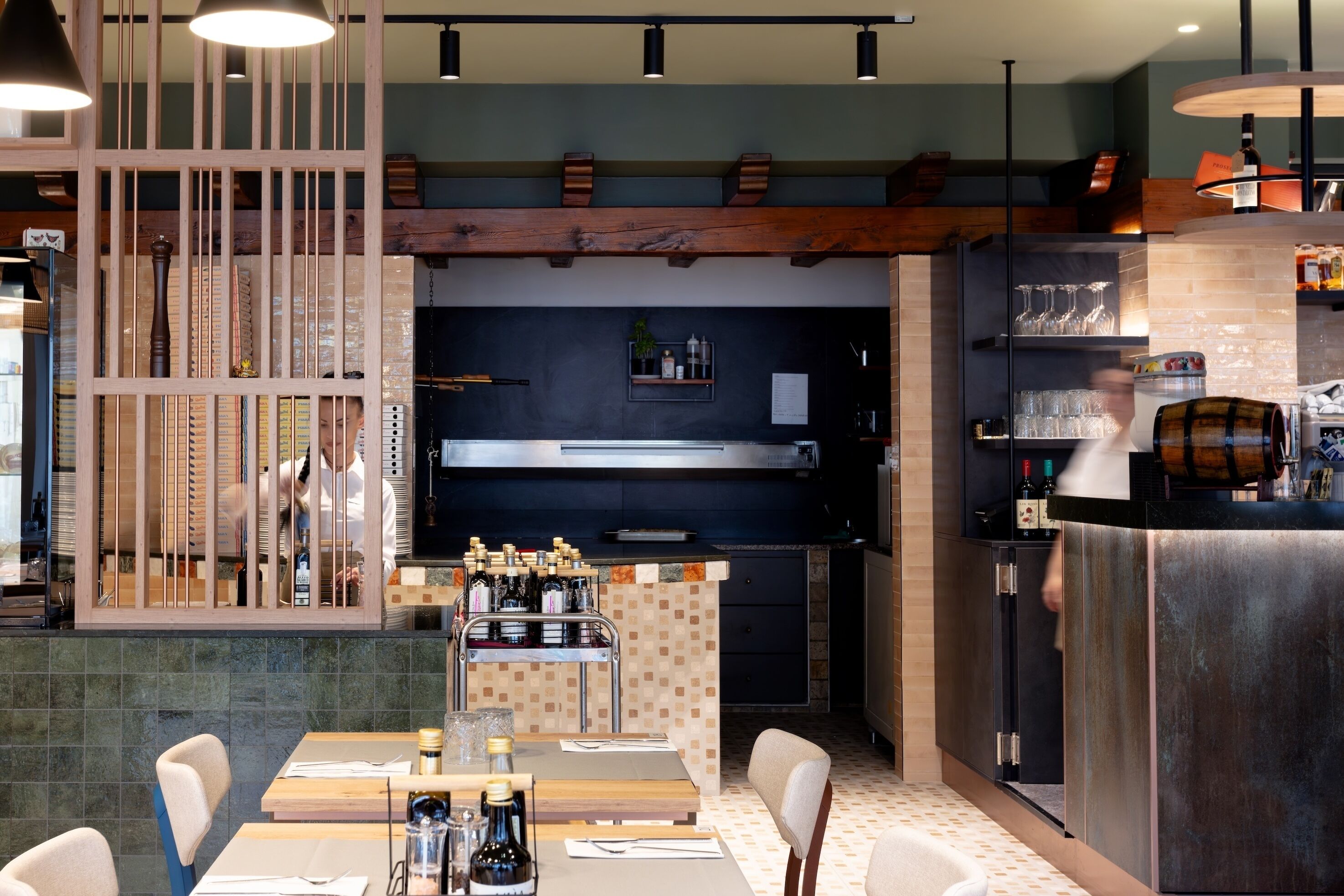 A restaurant interior with a bar area, seating, and a counter with bottles.