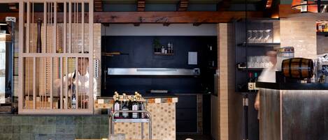 A restaurant interior with a bar area, seating, and a counter with bottles.
