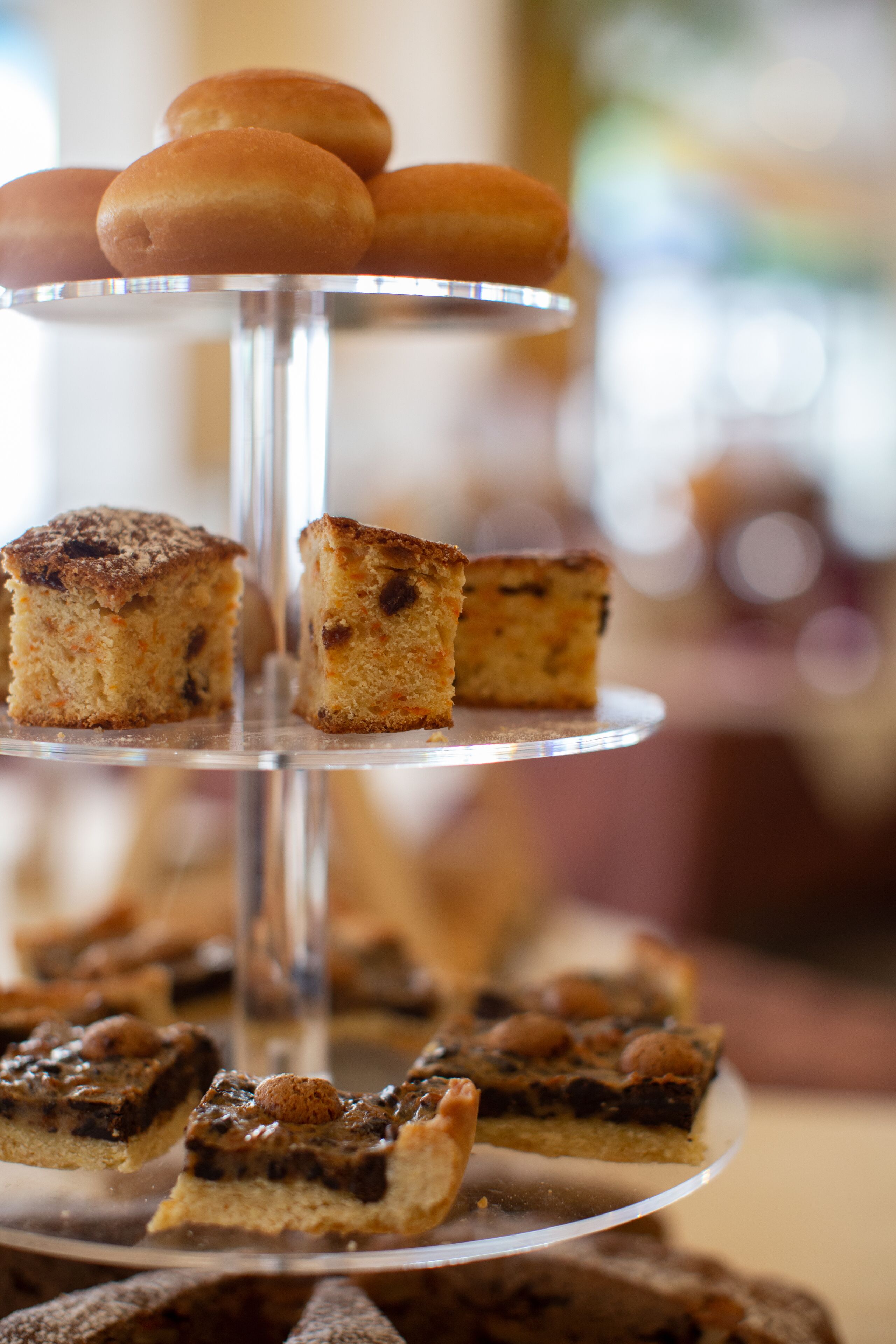 A multi-tiered dessert stand with various types of cakes and pastries.