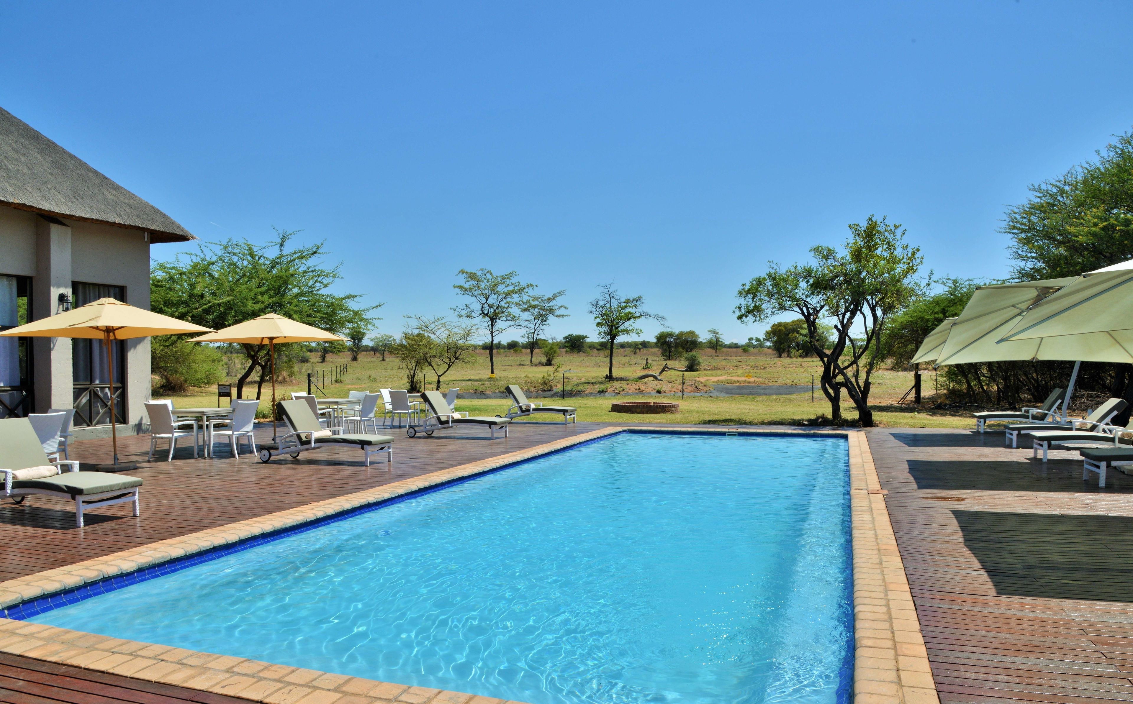 Alberca al aire libre, sombrillas en la alberca y camastros 