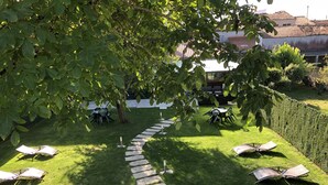 Un jardín con un sendero de piedra que lleva a una zona de estar con mesas y sillas.