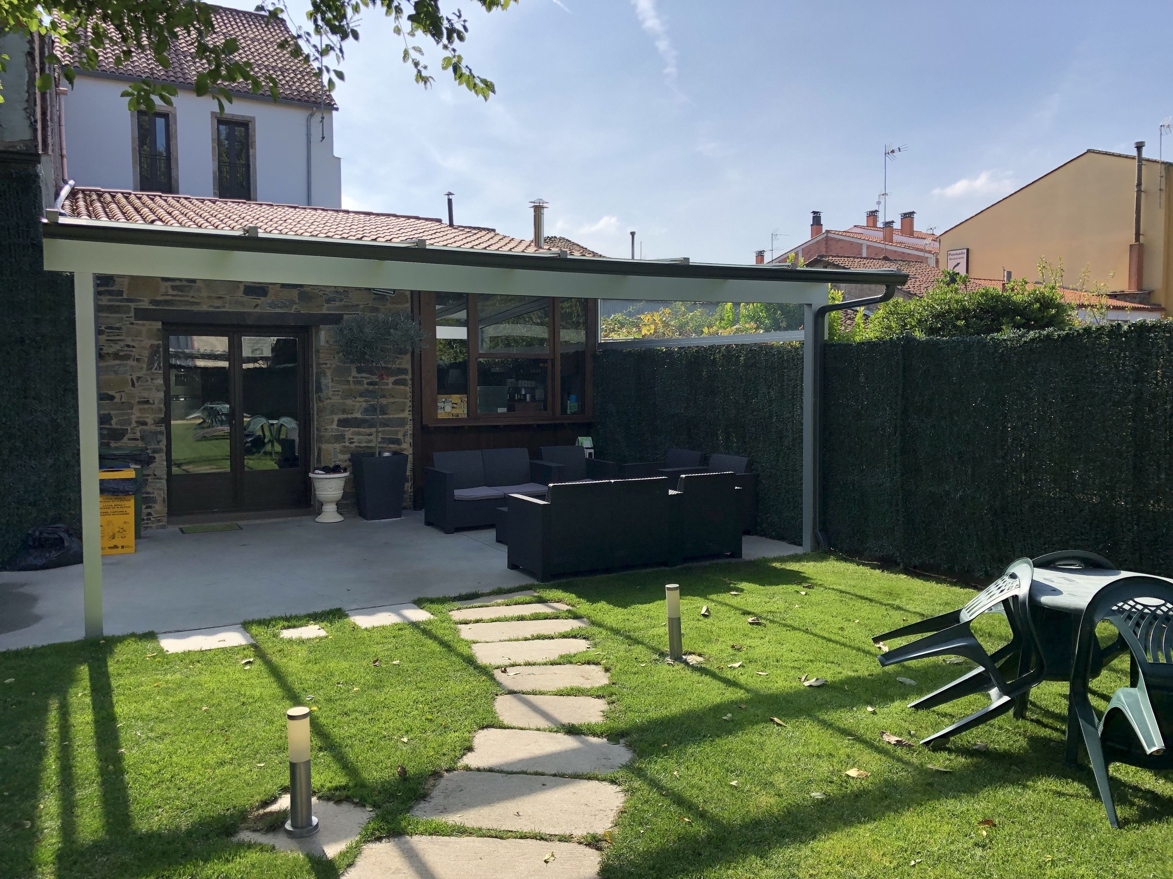 A patio area with a stone wall, outdoor seating, and a clear path.
